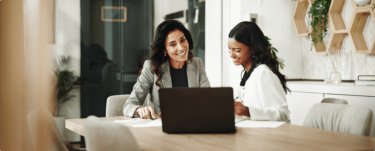 Two women working together on laptop.